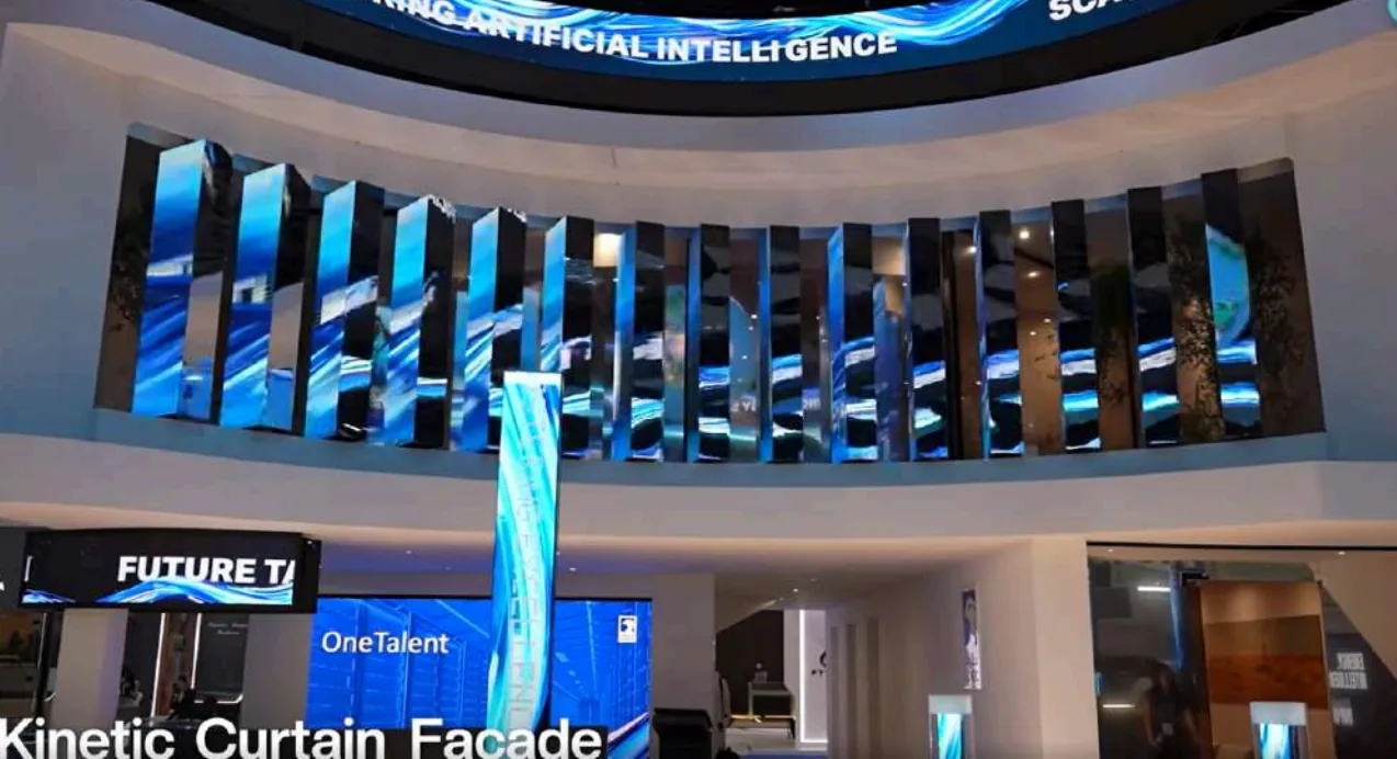 The kinetic curtain facade above the ADNOC stand, totems angled mid-show